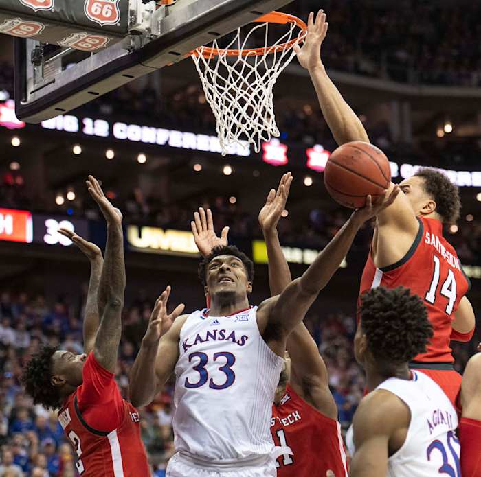 Mar 12, 2022; Kansas City, MO, USA; Kansas Jayhawks forward David McCormack (33) shoots the ball against Texas Tech Red Raiders forward Marcus Santos-Silva (14) and Texas Tech Red Raiders guard Davion Warren (2) in the second half at T-Mobile Center. Mandatory Credit: Amy Kontras-USA TODAY Sports